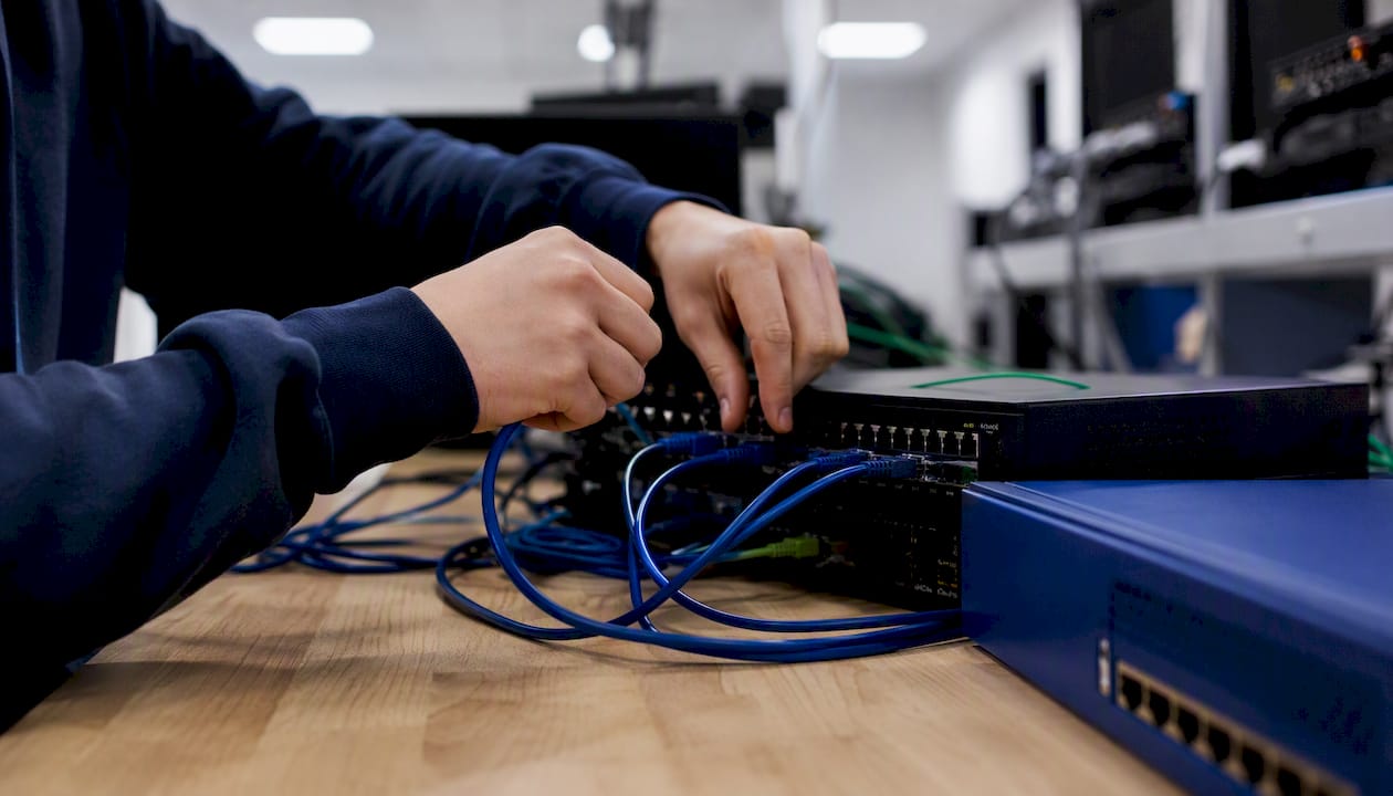 Hands connecting cables on cybersecurity hardware