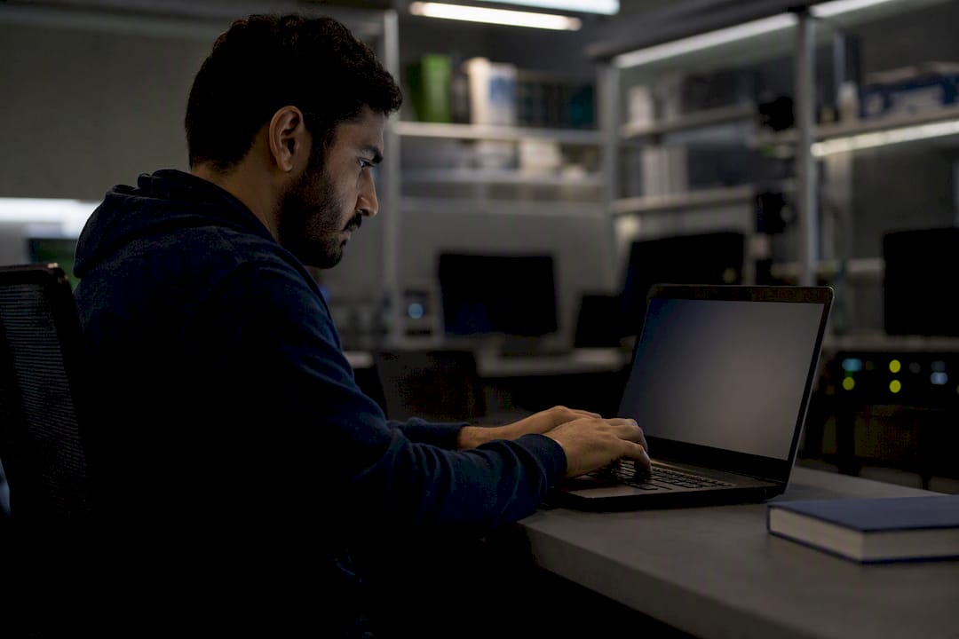 Hands updating detection rules on laptop
